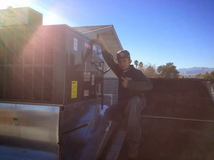 HVAC technician performing Heat Pump Repair on a rooftop unit in Southbridge Town